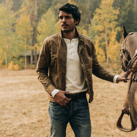 fit model wearing The Bomber Jacket in Field Tan Wax Canvas, with horse, Outerwear by Taylor Stitch