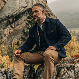 fit model wearing The Long Haul Jacket in Indigo Sashiko—sitting on rock, Outerwear by Taylor Stitch