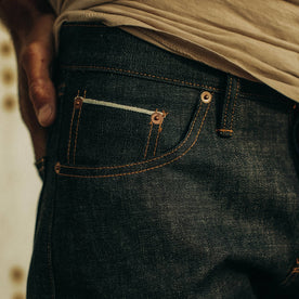 fit model posing in The Slim Jean in Natural Indigo Selvage, Bottoms by Taylor Stitch