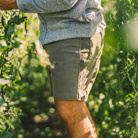 fit model wearing The Shaper Short in Stone Boss Duck in a grove., Bottoms by Taylor Stitch