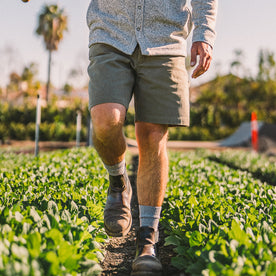 fit model walking through cropland in The Shaper Short in Stone Boss Duck, Bottoms by Taylor Stitch