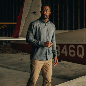 fit model posing next to a plane wearing The Jack in Navy Herringbone, Wovens by Taylor Stitch