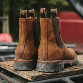 material shot outdoors of fit model wearing The Ranch Boot in Redwood Waxed Suede, back heel, Footwear by Taylor Stitch