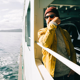 fit model wearing The Lombardi Jacket in Mustard Dry Wax, side shot on ferry, Outerwear by Taylor Stitch