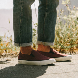 fit model wearing The Sano Slip-On in Rust Boss Duck, standing near grass, Footwear by Taylor Stitch