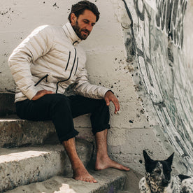 our fit model wearing The Taylor Stitch x Mission Workshop Farallon Jacket in fog—shot of model sitting down